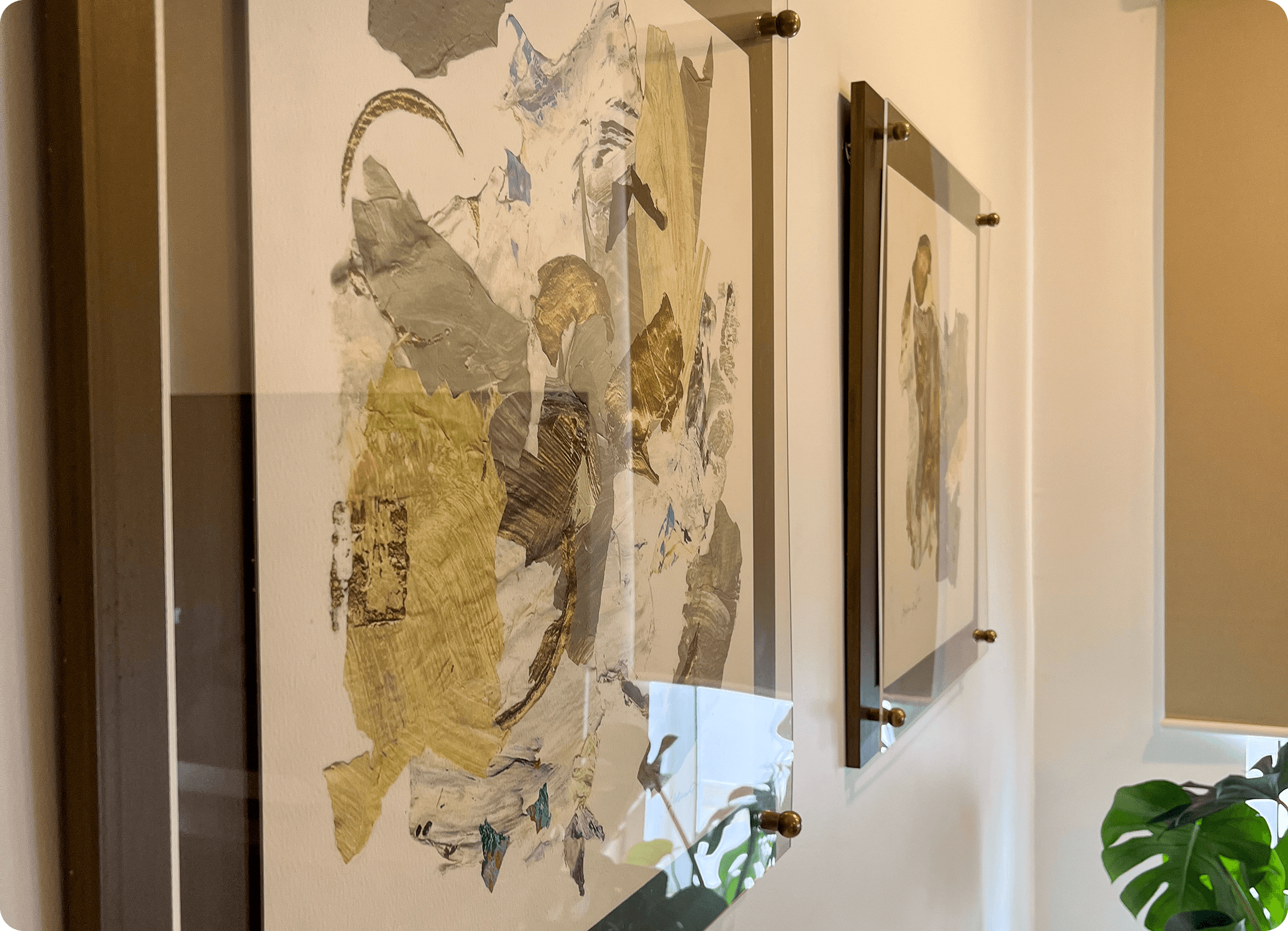 Curated interior hallway featuring framed abstract artworks mounted on brass pins